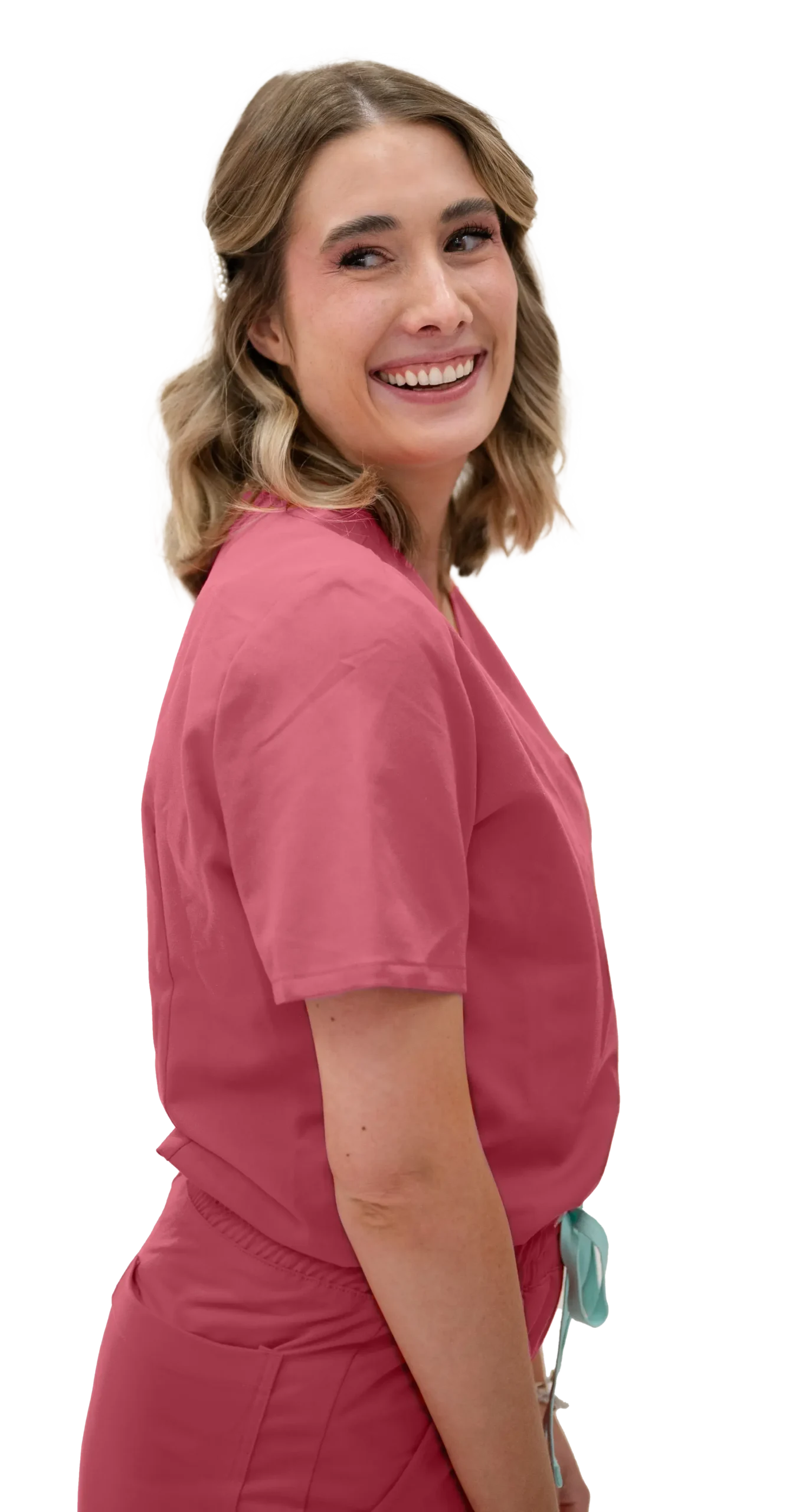 A woman with shoulder-length blonde hair is smiling and looking over her shoulder. She is wearing a pink outfit and appears to be in a cheerful mood.